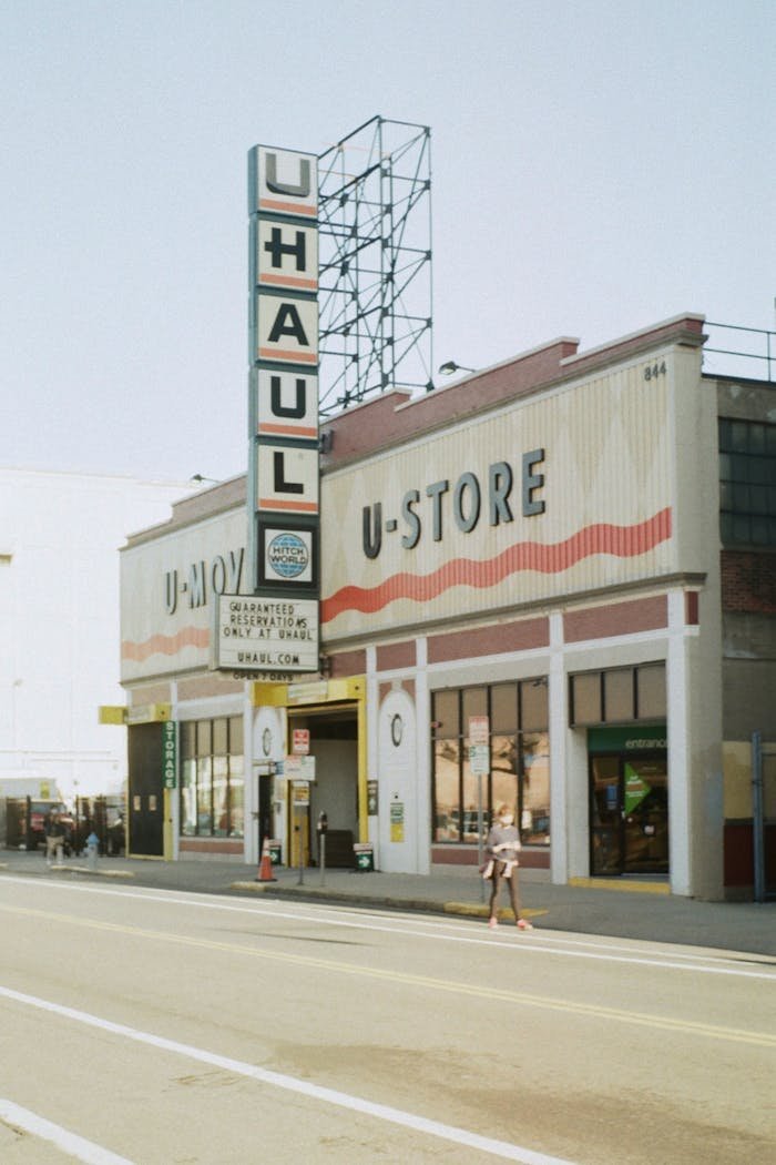 Urban scene depicting a U-Haul building with distinctive signage and street view.